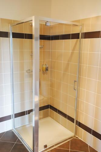 a shower with a glass door in a bathroom at Le Manoir du Golf in Publier