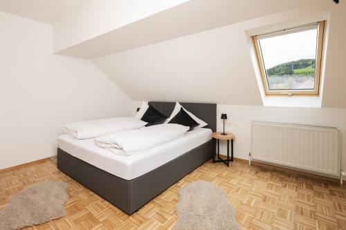 a bedroom with a bed with white sheets and a window at Centro 7 - Kristall Lungau in Tamsweg