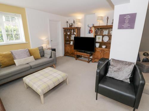 a living room with a couch and a chair at Jubilee Cottage in Stratford-upon-Avon