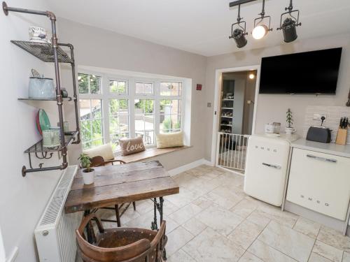 a kitchen with a wooden table and a counter top at Jubilee Cottage in Stratford-upon-Avon