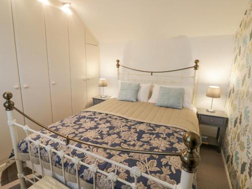 1 dormitorio con 1 cama con colcha azul y blanca en Jubilee Cottage en Stratford-upon-Avon