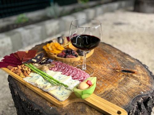 a glass of wine and food on a wooden table at Arkhilo's cottage in Dedoplis Tskaro