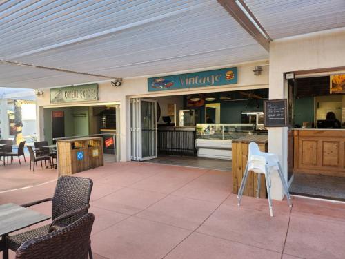 um restaurante com cadeiras e mesas e um balcão em MOBILHOME Lodge 3 chambres, 500m plage, camp 5 étoiles em Vendres