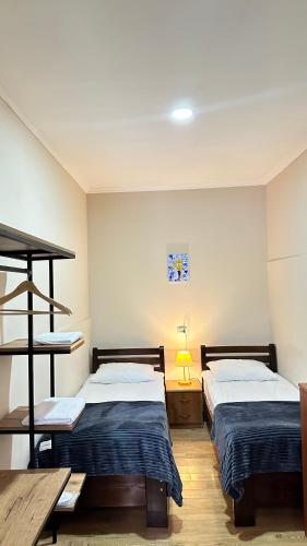 a room with two beds and a table at Meshia Apartment in Kazbegi