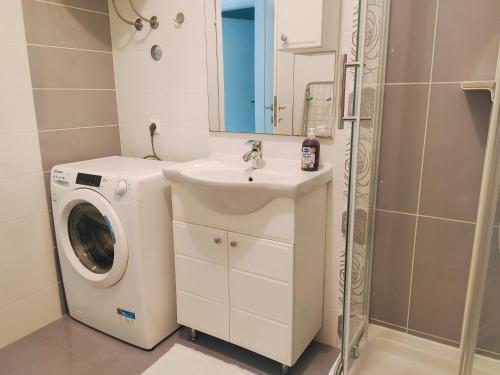 een badkamer met een wasmachine en een wastafel bij Siesta Apartments in Šibenik