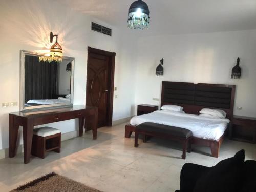 1 dormitorio con cama, escritorio y espejo en samara villas luxury en Sharm El Sheikh