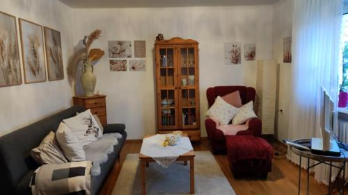 ein Wohnzimmer mit einem Sofa und einem Stuhl in der Unterkunft Ferienwohnung Sartorius in Bensheim
