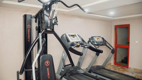 a gym with two tread machines in a room at J's Place Hotel in Abuja
