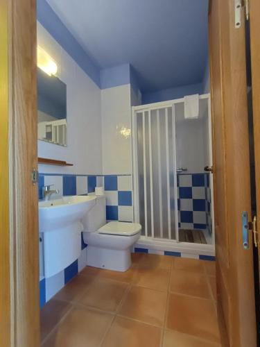 baño azul y blanco con aseo y lavamanos en Cal Emilia, en Ossó de Sió