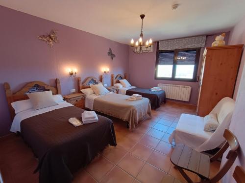 um quarto de hotel com duas camas e uma cadeira em Cal Emilia em Ossó de Sió