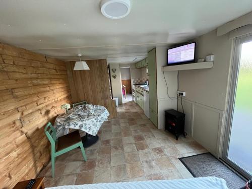 a living room with a table and a kitchen at Donegal Cabin with Hot tub Option in Dernacally