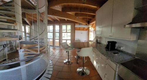 lichtdurchflutetes Architektenhaus في بالينغن: مطبخ بدولاب بيضاء وسقف خشبي