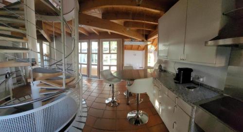 a kitchen with white cabinets and a wooden ceiling at lichtdurchflutetes Architektenhaus in Balingen