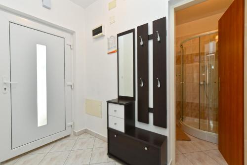 a bathroom with a black dresser and a mirror at Apartments Nevina 1230 in Pula