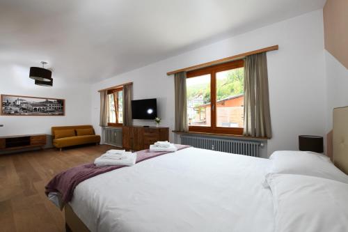 1 dormitorio con 2 camas blancas y ventana en 7rooms Losone, en Losone