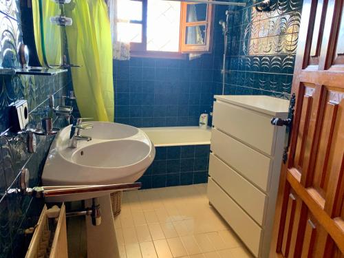 een blauw betegelde badkamer met een wastafel en een bad bij Valde Housing Cala Canyelles House in Lloret de Mar