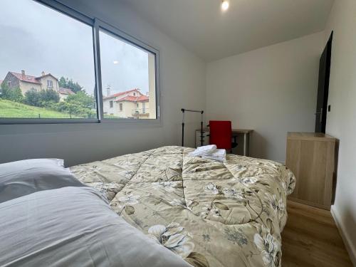 ein Bett in einem Zimmer mit einem großen Fenster in der Unterkunft F3 charmant neuf et équipé avec balcon "Wailly" in Clermont-Ferrand
