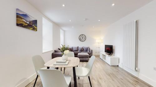 uma sala de estar com uma mesa e um sofá em Spacious three bedroom apartment with Valley views em Abertillery
