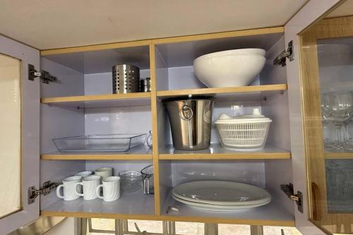 une armoire remplie de assiettes, de bols et de vaisselle dans l'établissement Serene Modern Farmhouse Retreat, 