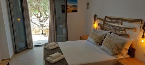 een slaapkamer met een bed met 2 kussens erop bij Selinopetra Rooms in Elafonisos
