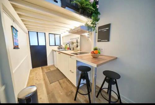 une cuisine avec un comptoir et des tabourets dans une pièce dans l'établissement Le cozy, à Villeurbanne