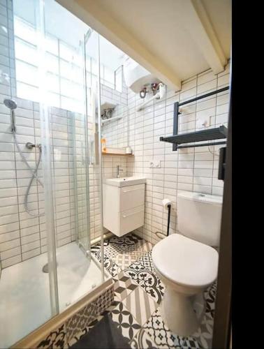 une salle de bain avec toilettes et douche en verre dans l'établissement Le cozy, à Villeurbanne