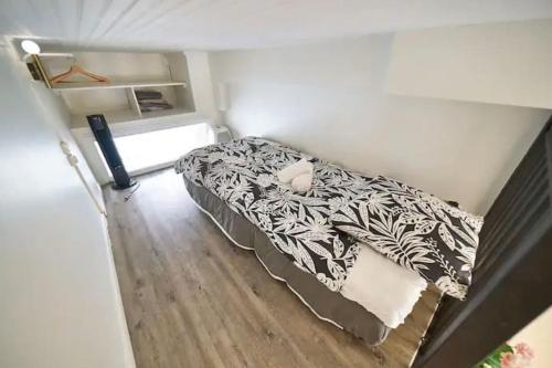 - une petite chambre avec un lit et une couette noire et blanche dans l'établissement Le cozy, à Villeurbanne