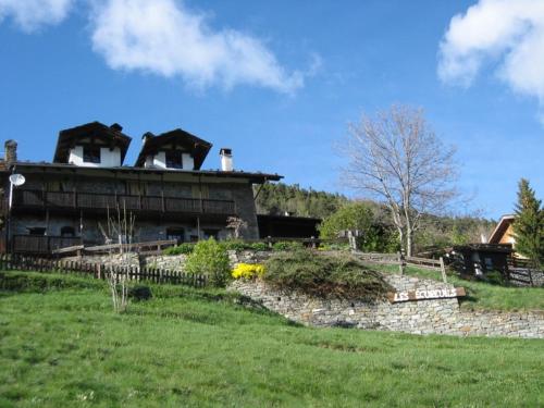 un bâtiment sur une colline avec un champ vert dans l'établissement Agriturismo Les Ecureuils, à Saint-Pierre
