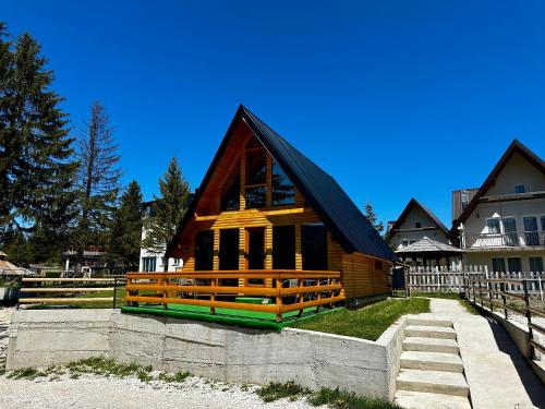 una pequeña casa de madera con techo negro en Vlasic Odmor - Villa Krajina V, en Vlašić