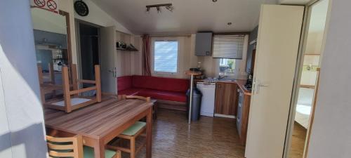 mała kuchnia i salon z czerwoną kanapą w obiekcie Mobil home Familial w mieście La Roque-dʼAnthéron