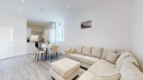 a living room with a couch and a table at Spacious three bedroom apartment with Valley views in Abertillery
