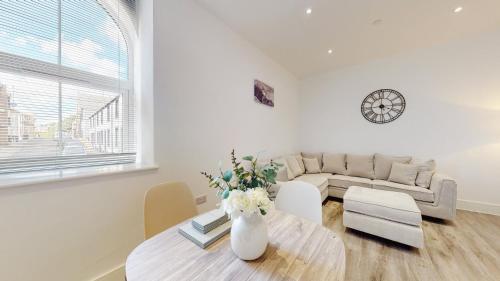 ein Wohnzimmer mit einem Tisch und einem Sofa in der Unterkunft Spacious three bedroom apartment with Valley views in Abertillery