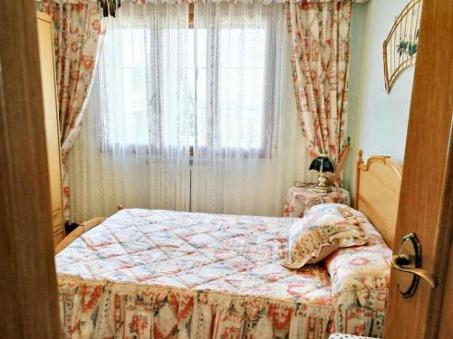 een kleine slaapkamer met een bed en een raam bij 4 bedrooms house with terrace at Nois Lugo in Barrosa