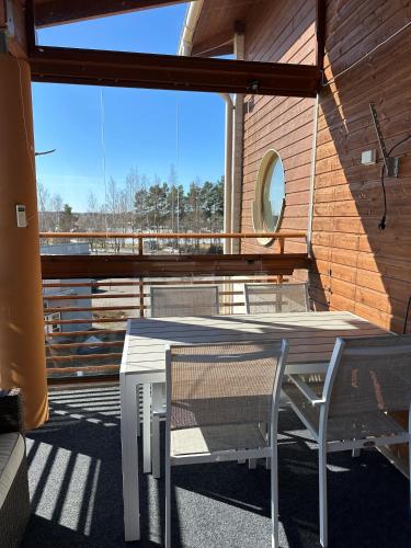 uma mesa branca e cadeiras numa varanda em Lomahuoneisto Lappajärvi Chalets 1 em Lappajärvi
