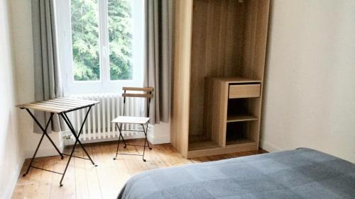 een slaapkamer met een bed en 2 stoelen en een raam bij Maison de 4 chambres avec jardin clos et wifi a Pontorson in Pontorson
