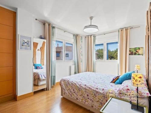 una camera con un letto e due finestre di Casa pareada en los pinos de Alhaurín Málaga ad Alhaurín de la Torre