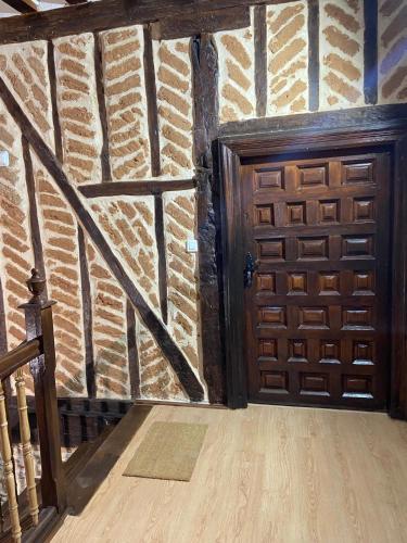a wooden door in a room with a brick wall at La Casona de 1717 in El Burgo de Osma
