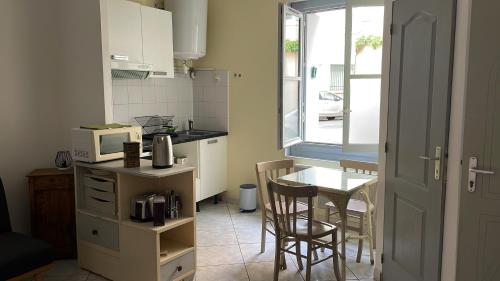 eine kleine Küche mit einem Tisch und einer Mikrowelle in der Unterkunft Studio in the heart of historical house in Villeneuve-lès-Béziers