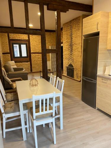 a kitchen and dining room with a white table and chairs at La Casona de 1717 in El Burgo de Osma