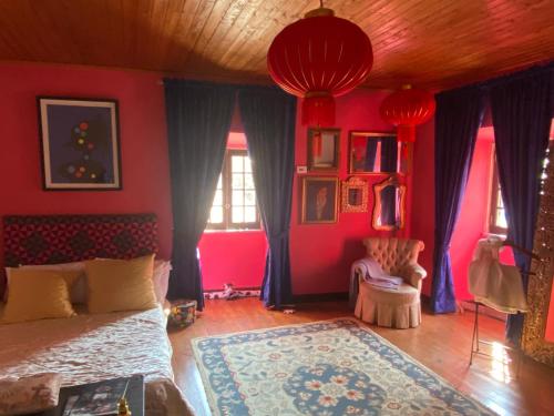 1 dormitorio con paredes rojas y 1 cama con alfombra en Casa Solarenga, en Bombarral