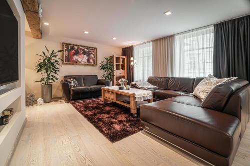 Una sala de estar con un sofá de cuero y una mesa. en Luxurious and Royal Apartment in the Old Town, en Bratislava
