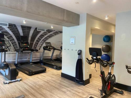 een fitnessruimte met verschillende loopbanden en hometrainers in een kamer bij 437-Newly Renovated Lux Apt w Gym and Courtyard in Hoboken