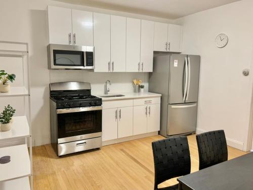 eine Küche mit weißen Schränken, einem Herd und einem Kühlschrank in der Unterkunft 231- 2B 1B Easy Commute to NYC in Hoboken