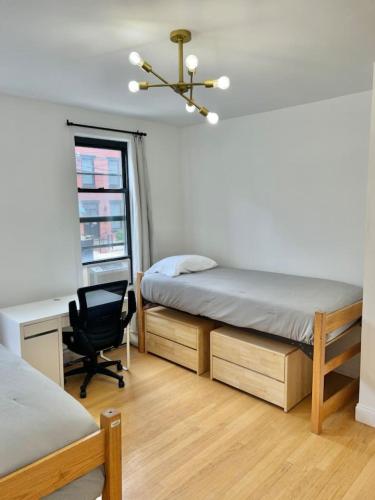 1 Schlafzimmer mit 2 Betten, einem Schreibtisch und einem Stuhl in der Unterkunft 231- 2B 1B Easy Commute to NYC in Hoboken