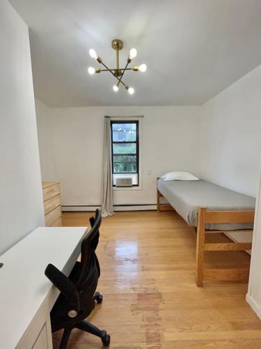 Schlafzimmer mit einem Bett, einem Schreibtisch und einem Stuhl in der Unterkunft 231- 2B 1B Easy Commute to NYC in Hoboken