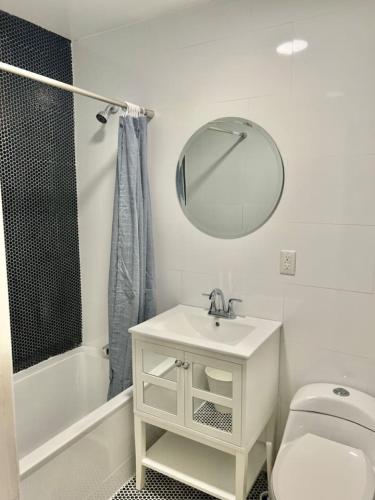 ein weißes Badezimmer mit einem Waschbecken und einem Spiegel in der Unterkunft 231- 2B 1B Easy Commute to NYC in Hoboken