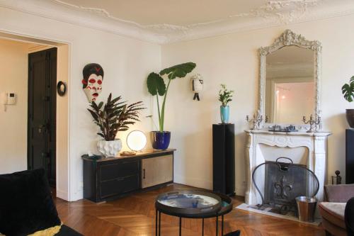 sala de estar con chimenea y espejo en Spacious luxury Haussmanian apartment, en París