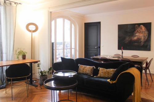 sala de estar con sofá negro y mesa en Spacious luxury Haussmanian apartment, en París