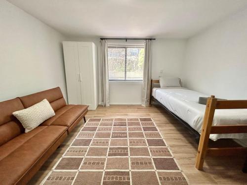 Cette chambre dispose d'un canapé, d'un lit et d'une fenêtre. dans l'établissement 0230-Central Cozy 2B 1B, à Hoboken
