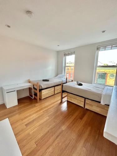a room with two beds and a desk and two windows at 318-2 Bedroom 2 Bathroom Apt W In Unit Laundry in Hoboken